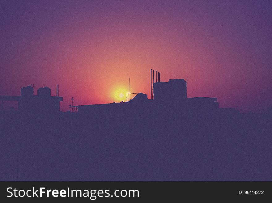 A city view with the sunset behind the buildings. A city view with the sunset behind the buildings.