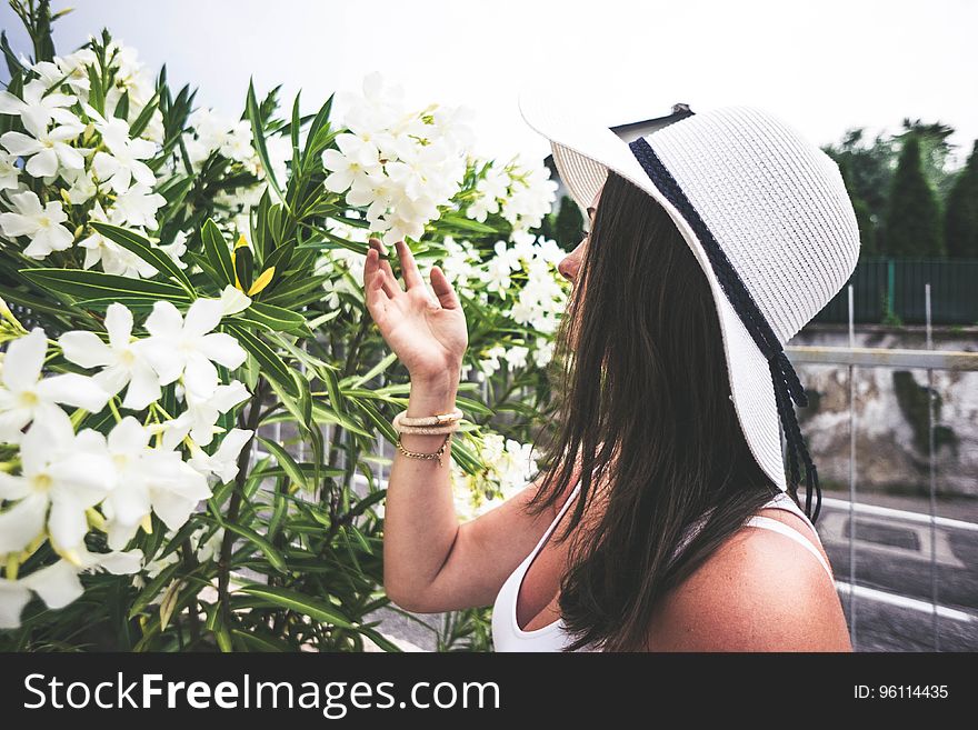 A woman smelling Nerium oleander flowers.