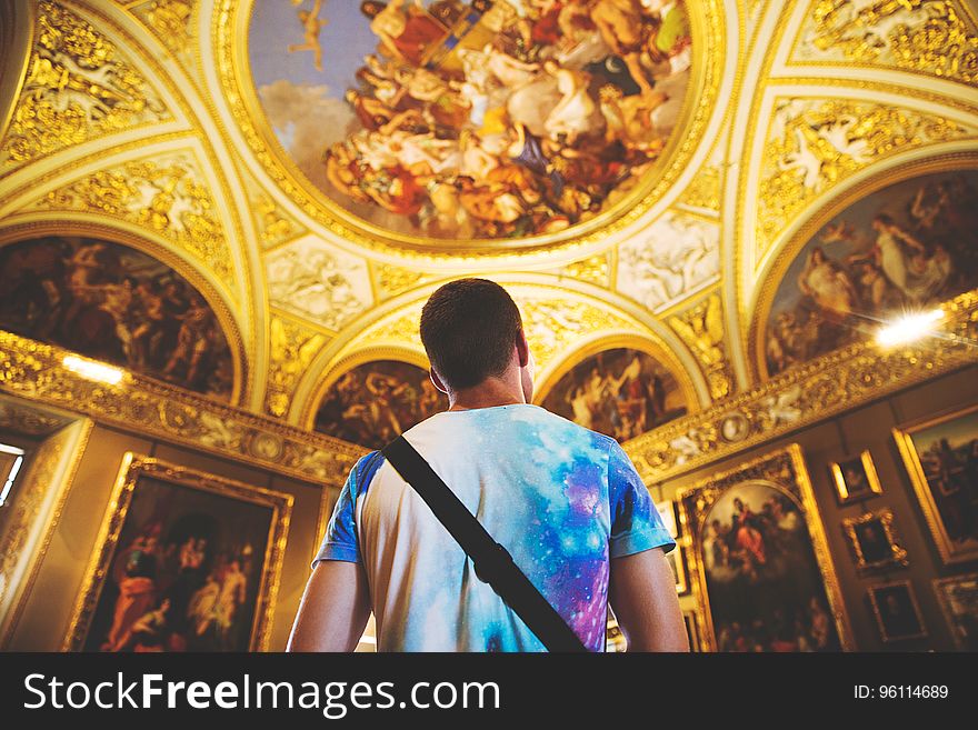 Back of man standing in ornate gild cathedral interior. Back of man standing in ornate gild cathedral interior.