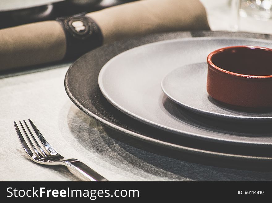 A table setting with plates, napkins and cutlery.