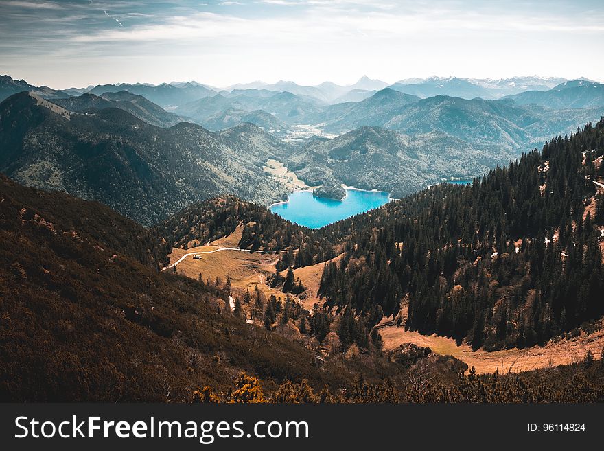 A panoramic view of a turquoise mountain lake in a valley.