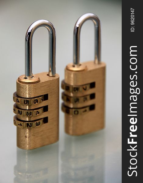 2 regular bronze locks over glass surface. 2 regular bronze locks over glass surface