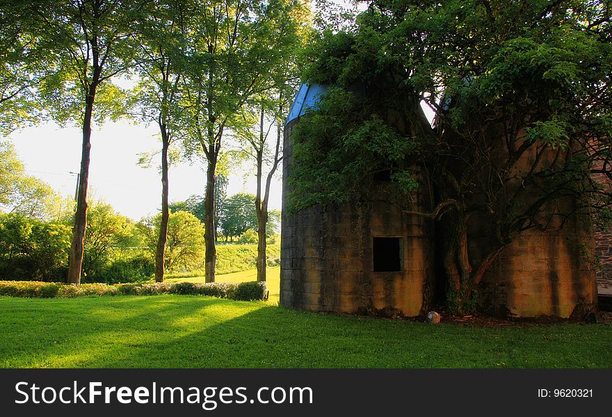 Landscape with green field and a old building