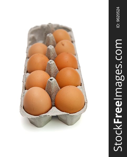 Nine brown eggs in box isolated