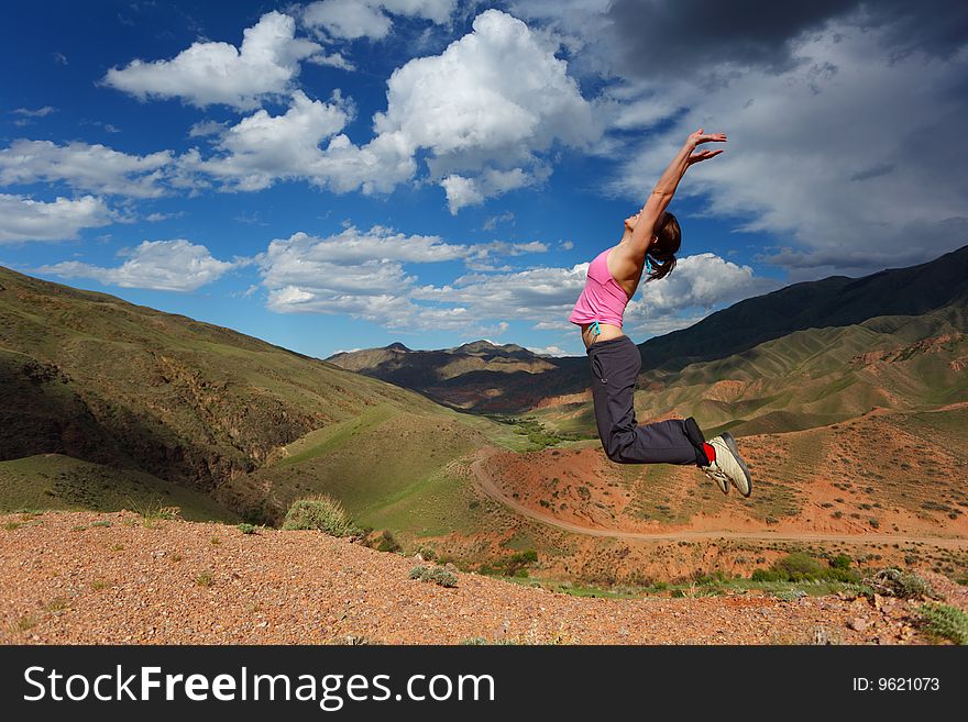 The girl jumping in top in mountains