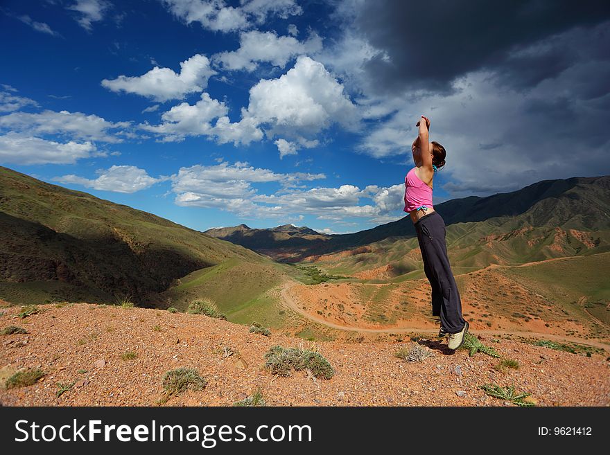 The girl jumping in top in mountains