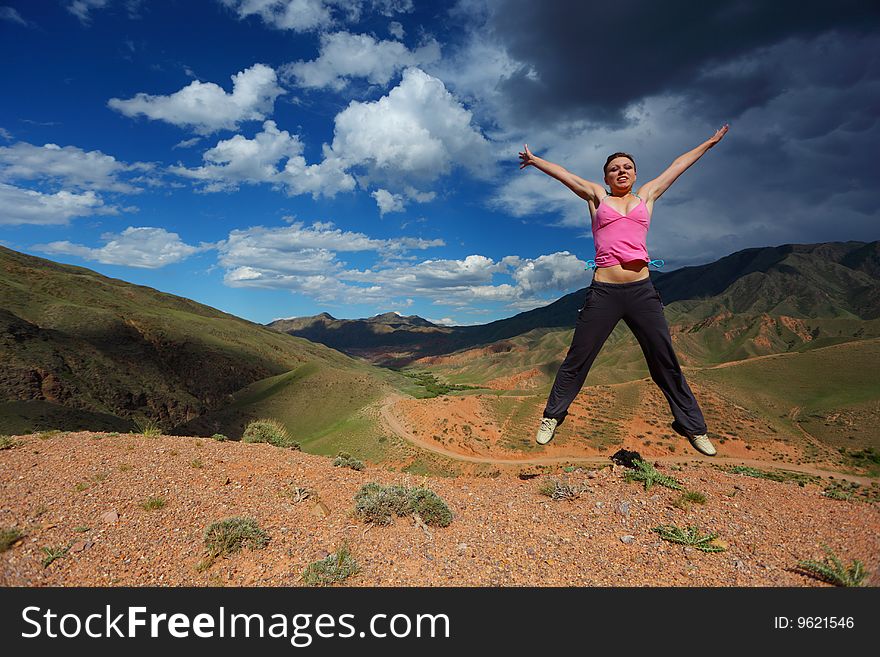 The girl jumping in top in mountains