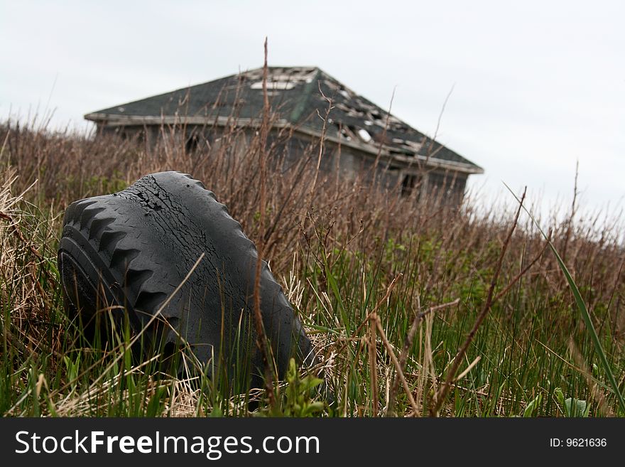 Old tire sits in the yard of an abandon house