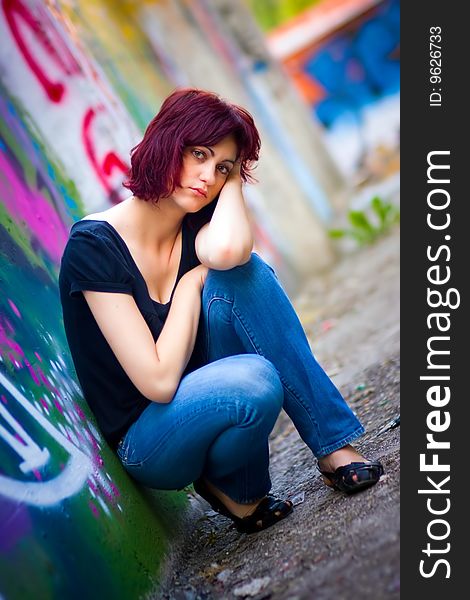 Girl with extraordinary eyes posing by the wall with graffiti on it. Girl with extraordinary eyes posing by the wall with graffiti on it