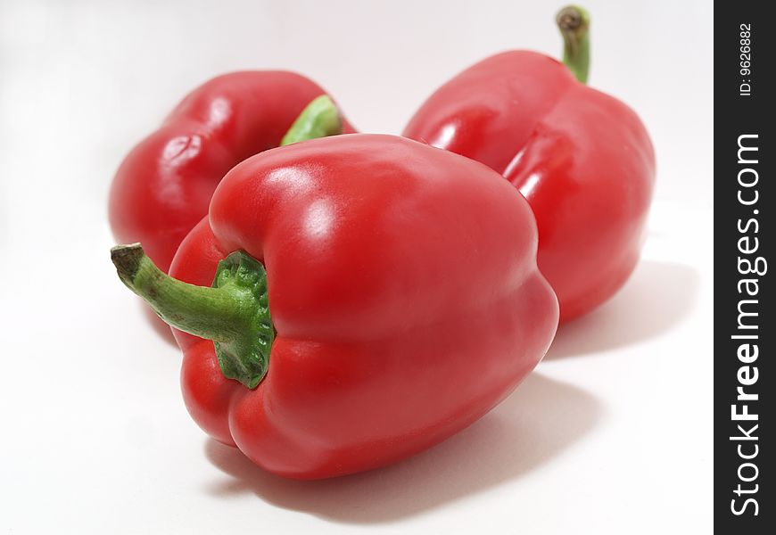 Color photograph of red peppers on a white background