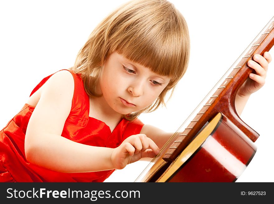 First lesson. Girl in red dress play the guitar. On white background.