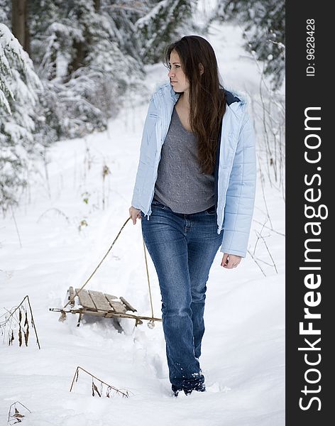 Pretty young woman pulling sled. Pretty young woman pulling sled
