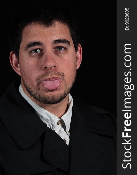 Male portrait with tongue sticking out isolated on black background