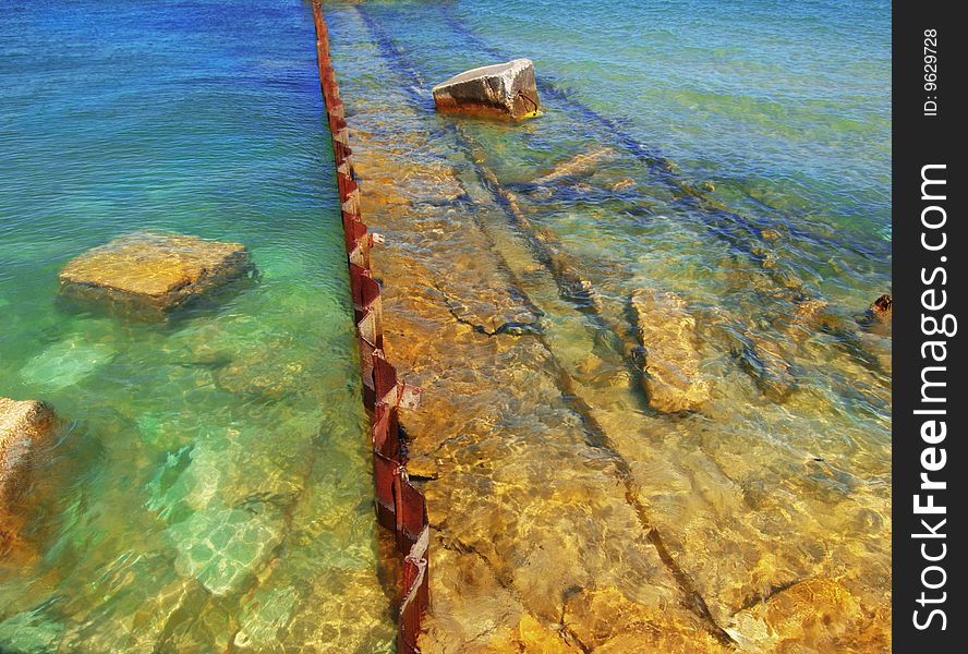 Submerged stones and metal from an old broken jetty. Submerged stones and metal from an old broken jetty.