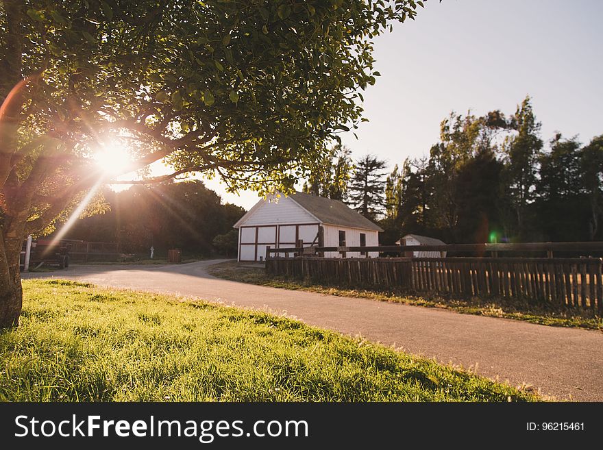 White and Grey House Beside Empty Road during Sunset