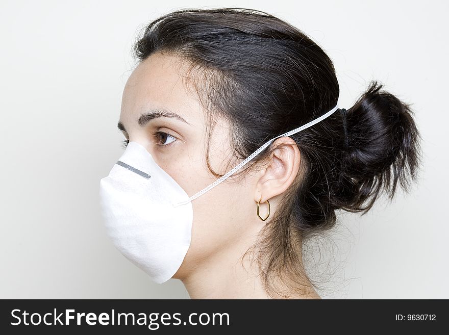 Young woman putting on a mask against swine flu