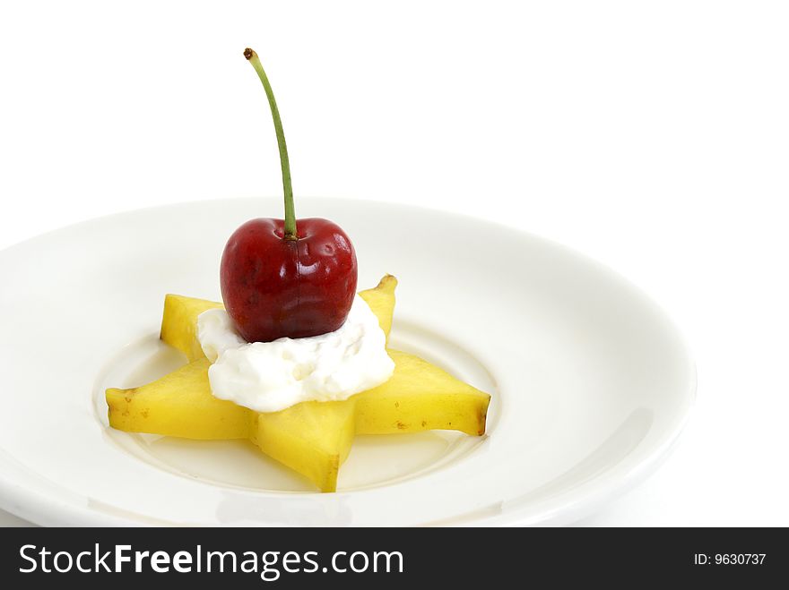 A piece of star-fruit with whipped cream and a cherry. A piece of star-fruit with whipped cream and a cherry.