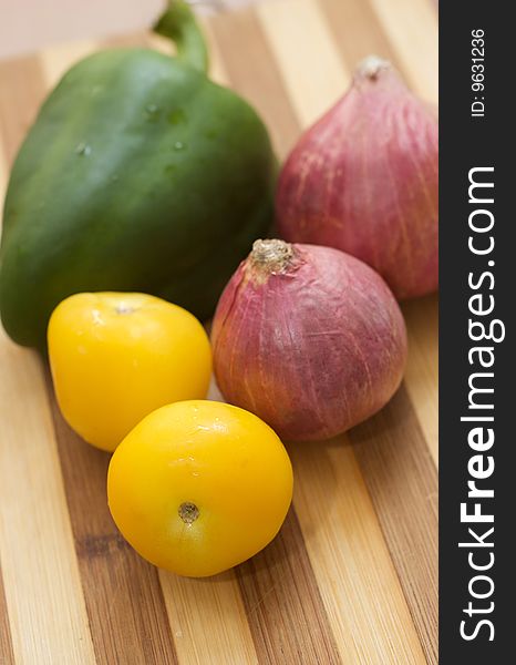 Fresh vegetables close up on wooden cutting board focus on tomato