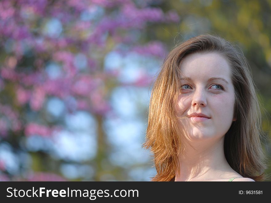 A head shot of a lovely young woman on a pleasant spring day at the park. A head shot of a lovely young woman on a pleasant spring day at the park.