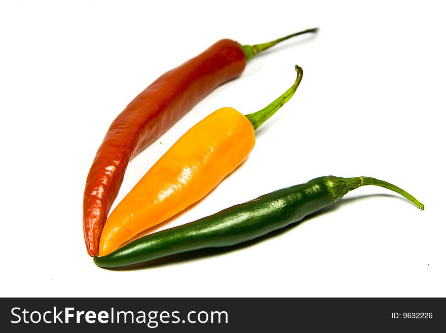 Multiple color chilies on white background