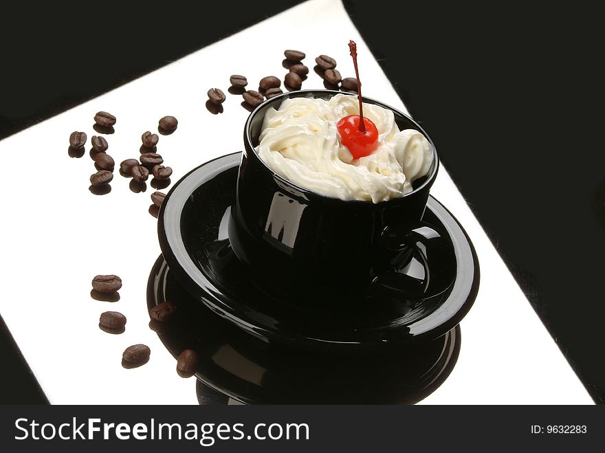 Cup with stirred cream and cherry on a black glass. Cup with stirred cream and cherry on a black glass