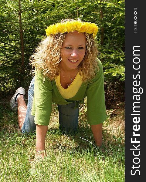 Curly girl with dandelion chain on knees