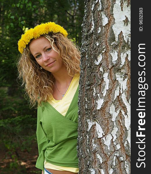 Curly girl with dandelion chain on head