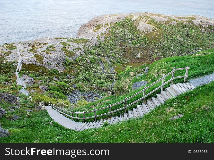 Steps on steep hillside leading to rocky ocean shoreline. Steps on steep hillside leading to rocky ocean shoreline.