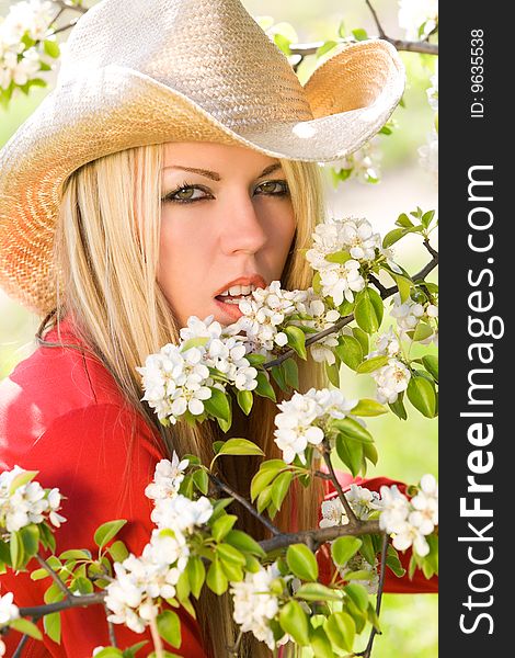 Pretty woman with cowboy hat and blossom trees. Pretty woman with cowboy hat and blossom trees