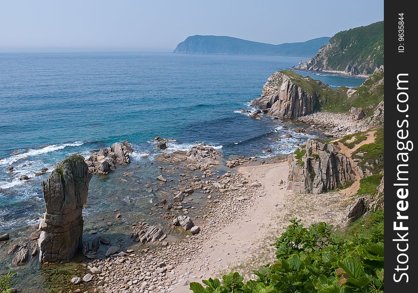 A small bay with alone tall rock. Japanese sea. A small bay with alone tall rock. Japanese sea.