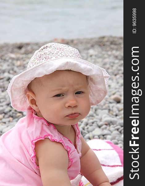 Summer shot - little girl with panama sitting on the beach. Summer shot - little girl with panama sitting on the beach