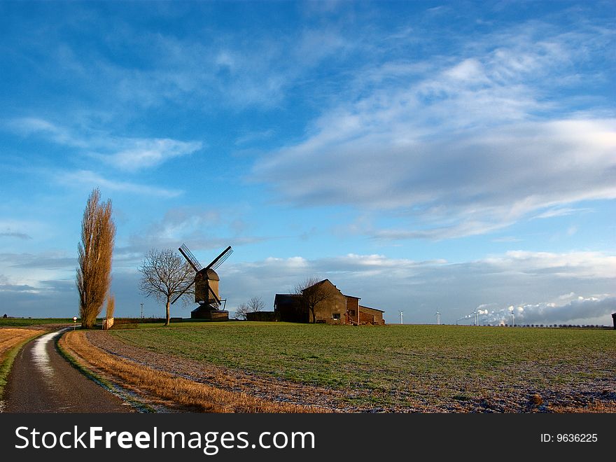 Morning light,field, traditional windmill and house, modern windmill generators on a background. Morning light,field, traditional windmill and house, modern windmill generators on a background