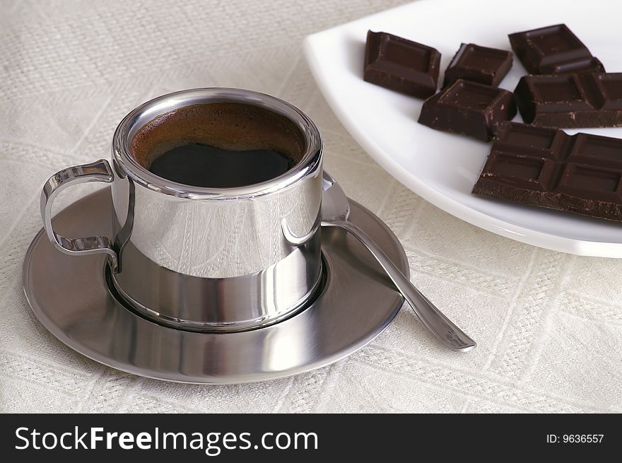 Cup of coffee slices of chocolate on a table. Cup of coffee slices of chocolate on a table