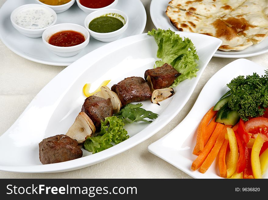 Appetizing Shish Kebab With Tomatoes And Greens