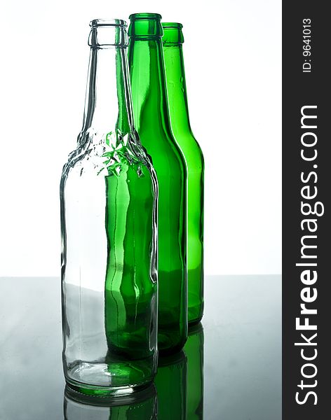 Transparent white beer bottle among green bottles