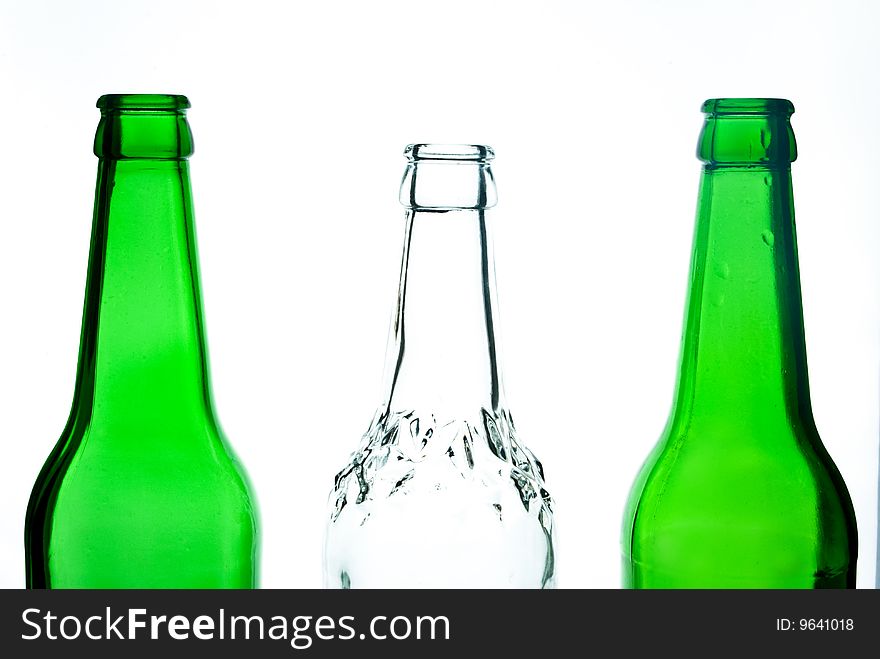 Transparent white beer bottle among green bottles