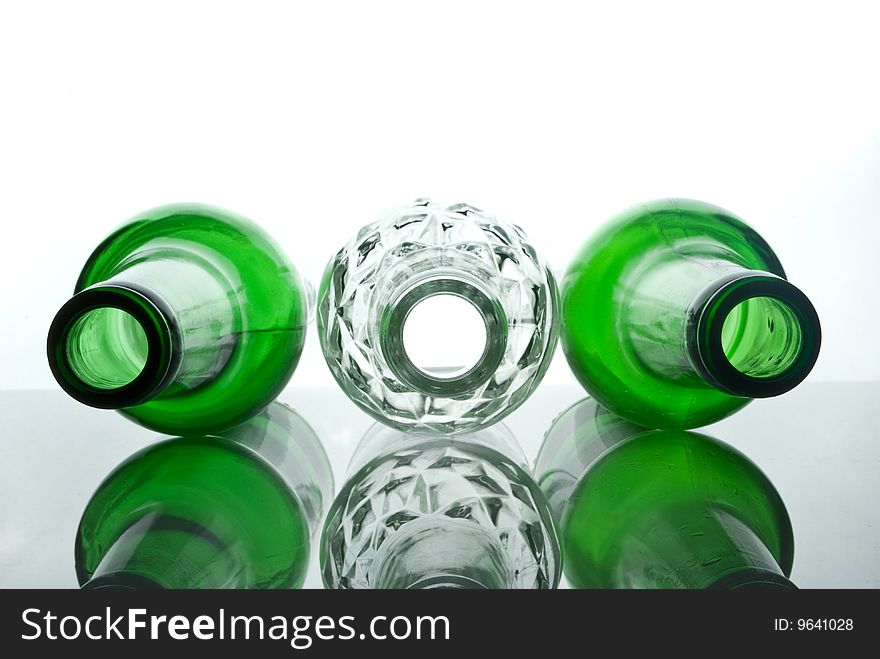 Transparent white beer bottle among green bottles