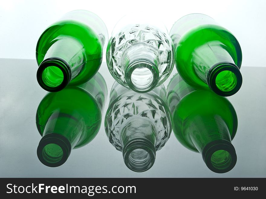 Transparent white beer bottle among green bottles. Transparent white beer bottle among green bottles