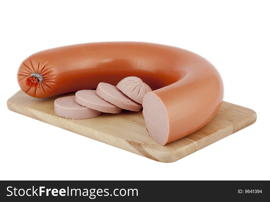 Sausage wreath with fine little extra, on chopping board isolated against white background