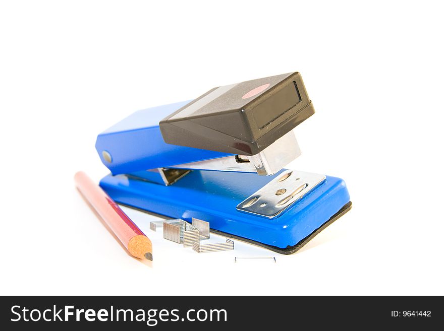 Single blue,chrome and black stapler with staples and pencil on a white background