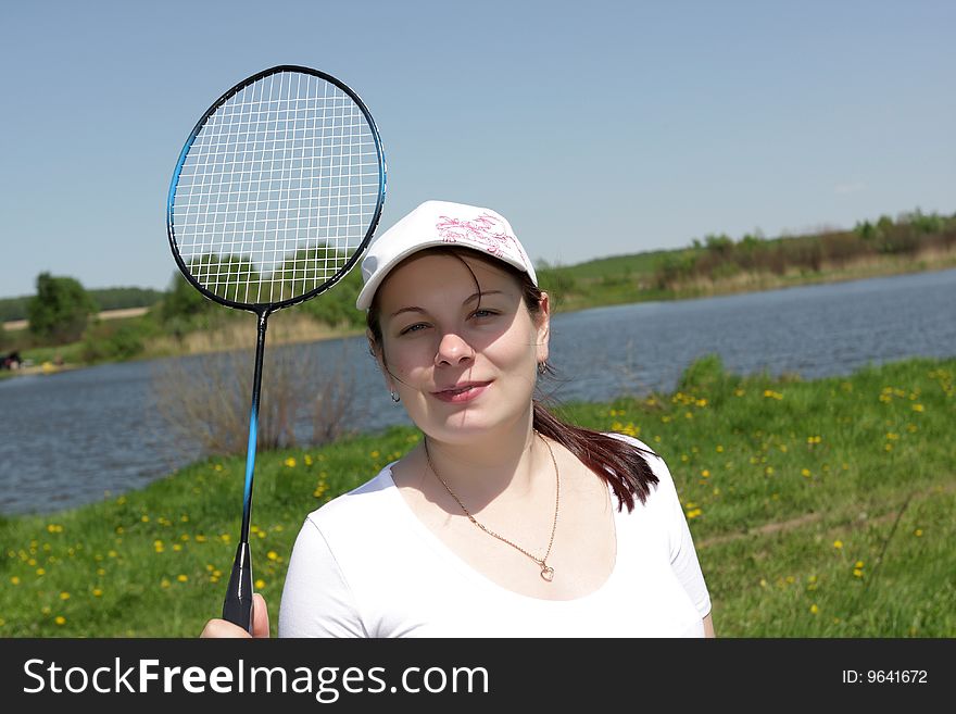 The young girl poses with badminton racket. The young girl poses with badminton racket