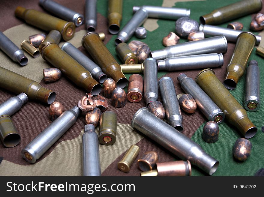 Bullets and sleeves on a camouflage background