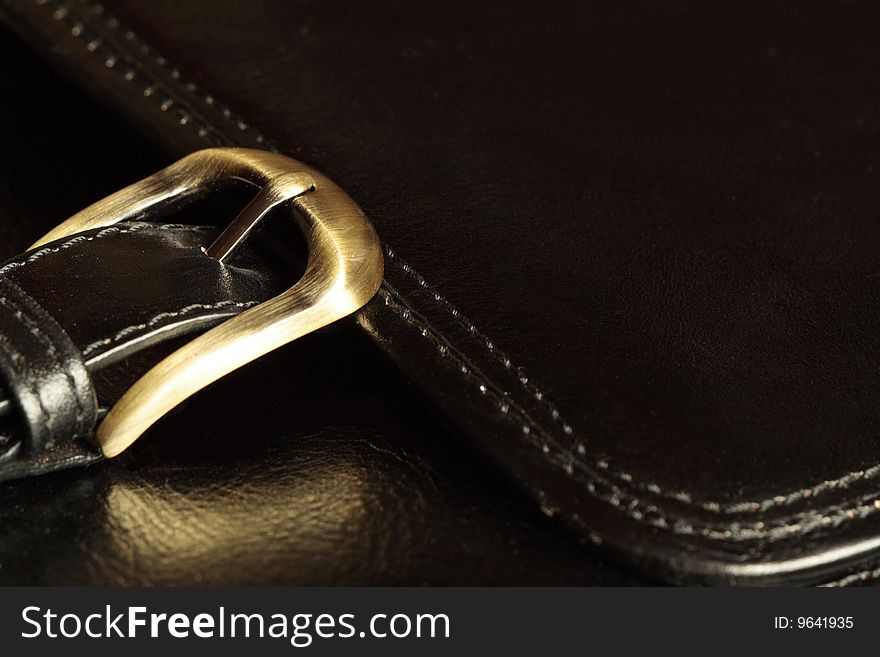 Abstract background with yellow metal buckle of black leather brief case