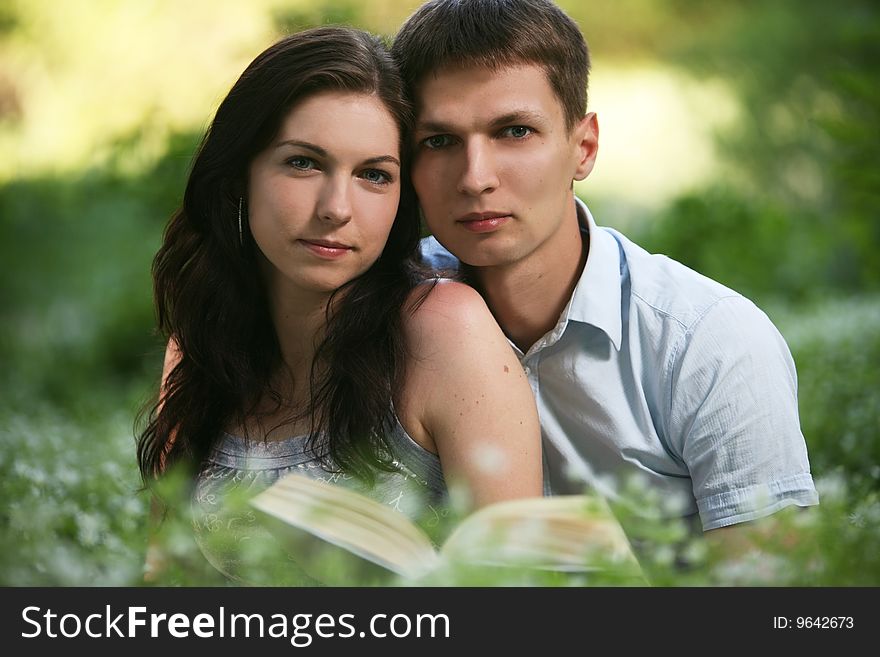 Man and woman sitting on the grass and reading. Man and woman sitting on the grass and reading.