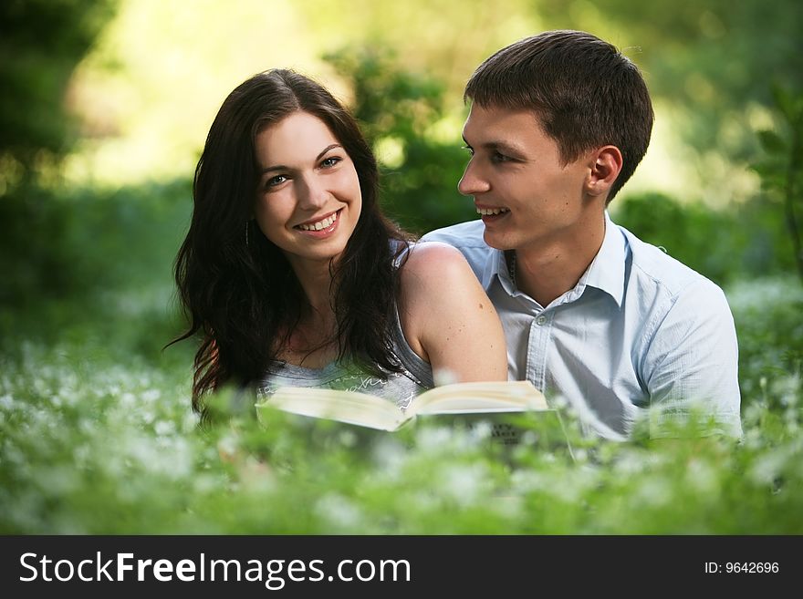 Man and woman sitting on the grass and reading. Man and woman sitting on the grass and reading.