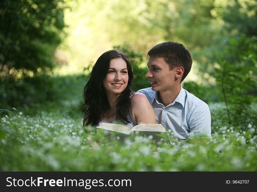 Man and woman sitting on the grass and reading. Man and woman sitting on the grass and reading.