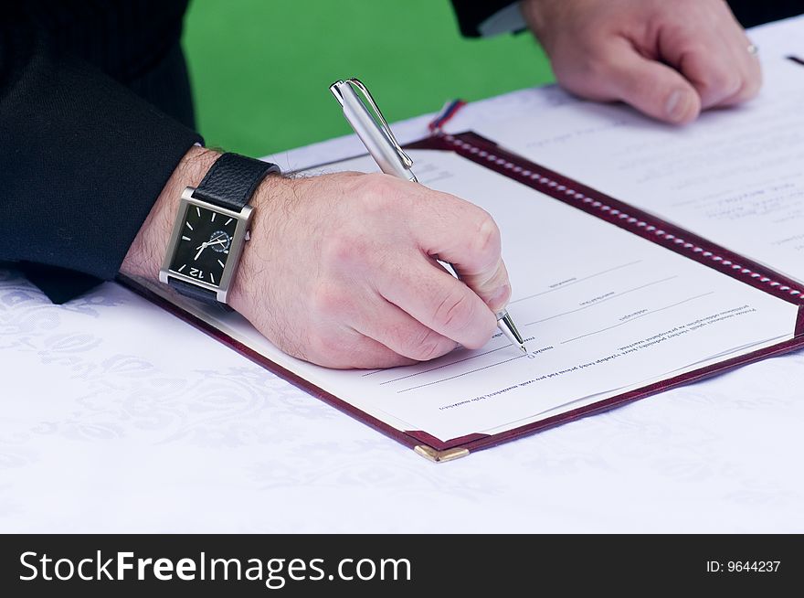 Man signing a document with a pen. Man signing a document with a pen