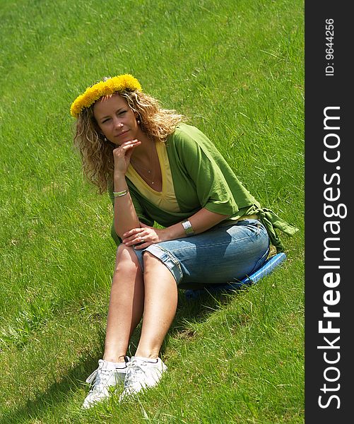 Curly girl with dandelion chain on head