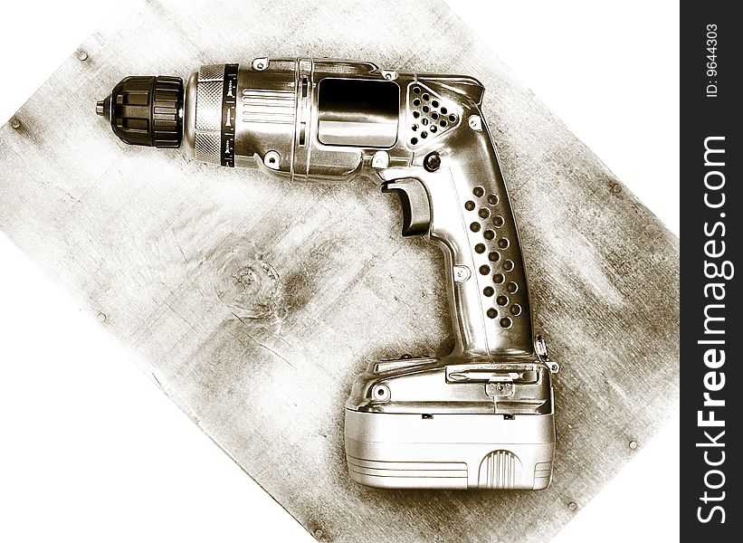 Classic looking cordless drill, laying on a piece of wood.