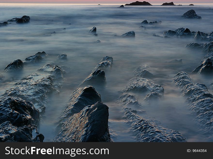 A misterious image of coast water and rocks at night time. A misterious image of coast water and rocks at night time